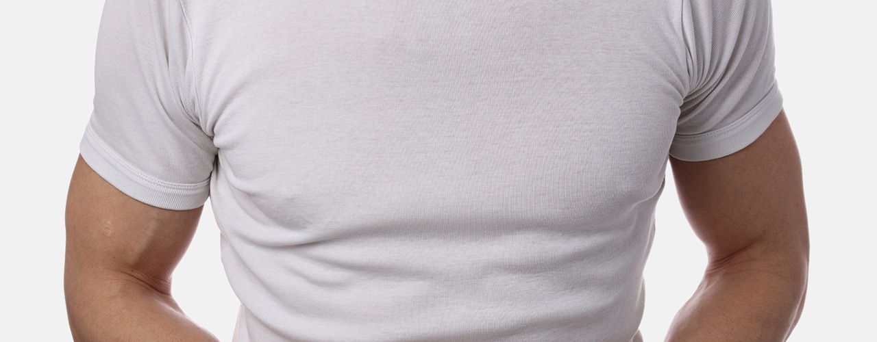 close up of man's chest in white t shirt against white background