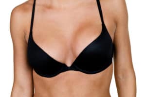 close up of woman's chest against white background in black bra